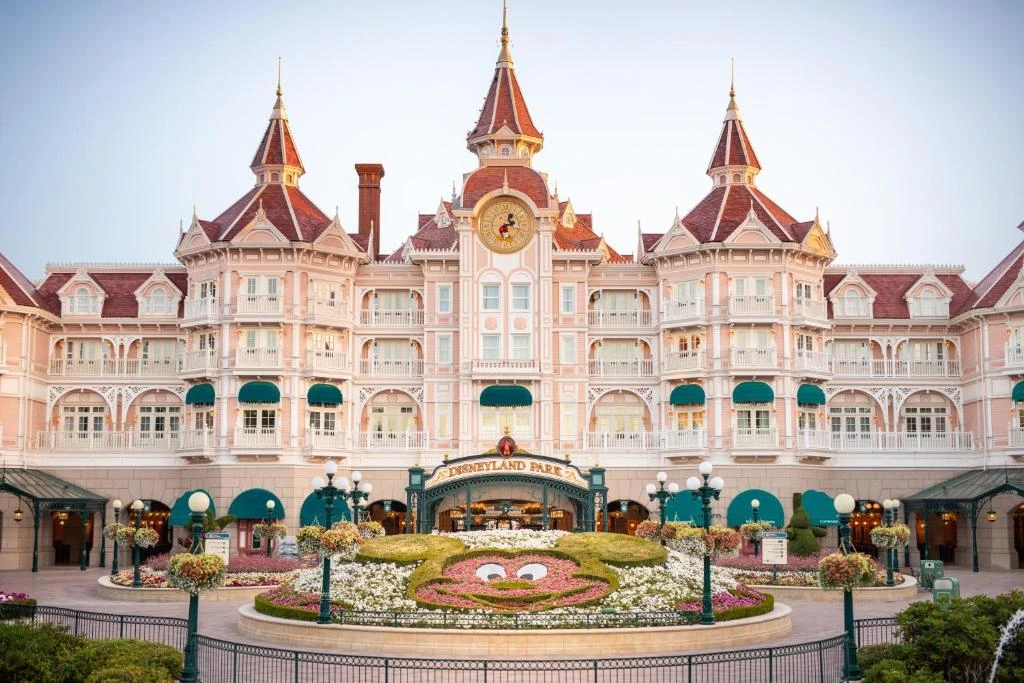 Façade rose et élégante du Disneyland Hôtel avec son style victorien et ses tourelles rappelant l’univers des princes et princesses.