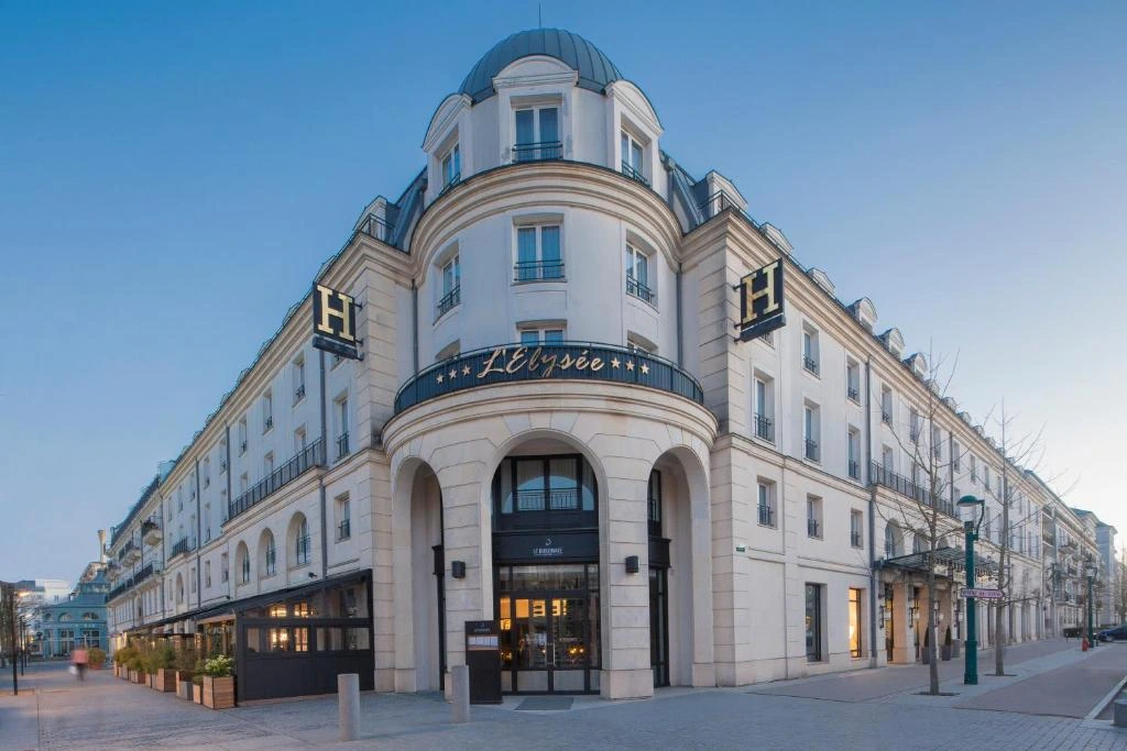 Façade élégante de l’Hôtel l’Elysée Val d’Europe, rappelant l’architecture haussmannienne dans un cadre moderne.